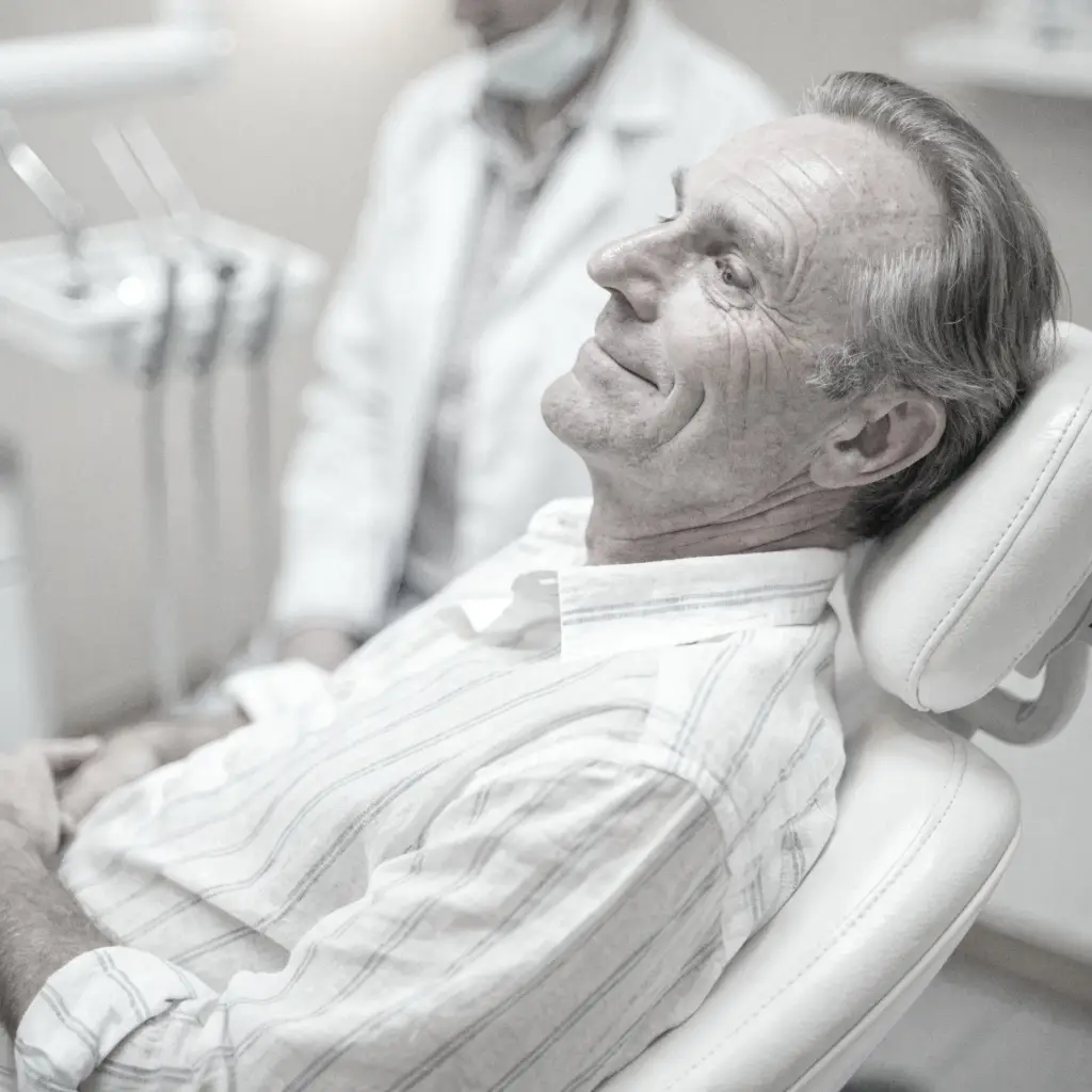 Hombre mayor en consultorio esperando por colocación de implantes dentales en DiBian Odontología, Belgrano
